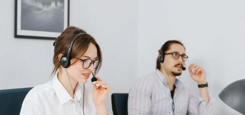 Two people working with headsets on